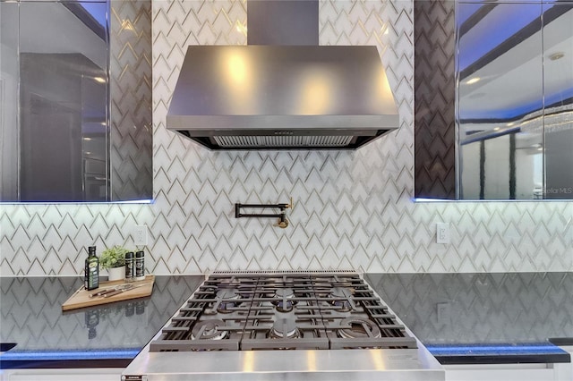 6522 Simone Shores Cir, Apollo Beach, FL 33572 - kitchen with wall chimney range hood, cooktop, and tasteful backsplash