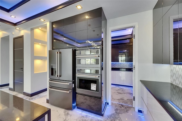 6522 Simone Shores Cir, Apollo Beach, FL 33572 - kitchen with stainless steel appliances, light marble finish flooring, modern cabinets, dark countertops, and decorative backsplash