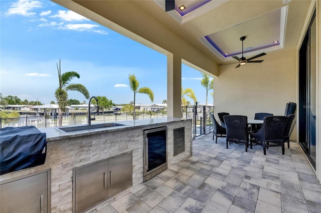 6522 Simone Shores Cir, Apollo Beach, FL 33572 - view of patio featuring beverage cooler, an outdoor kitchen, a sink, a water view, and outdoor dining area
