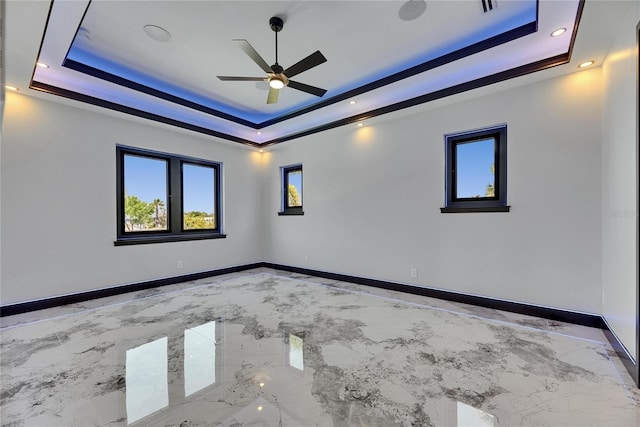 6522 Simone Shores Cir, Apollo Beach, FL 33572 - empty room with a raised ceiling, light marble finish floors, a ceiling fan, baseboards, and recessed lighting