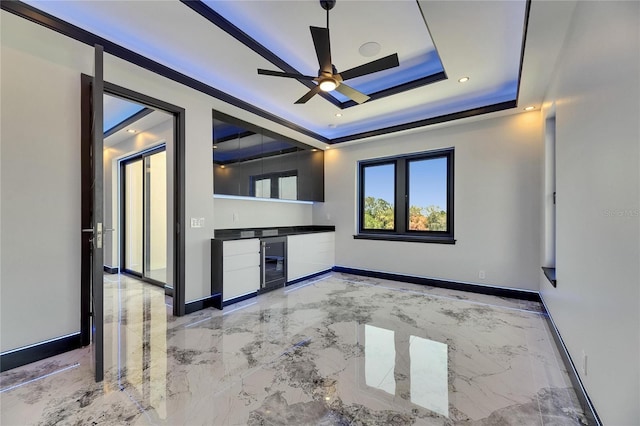 6522 Simone Shores Cir, Apollo Beach, FL 33572 - empty room featuring bar area, light marble finish floors, a tray ceiling, beverage cooler, and ceiling fan