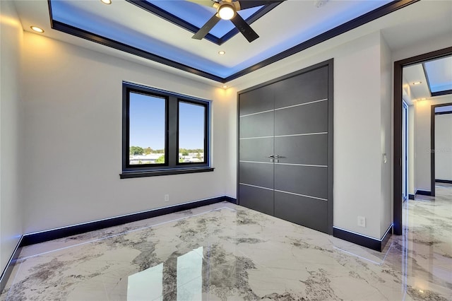 6522 Simone Shores Cir, Apollo Beach, FL 33572 - unfurnished bedroom featuring marble tiled floors, baseboards, recessed lighting, a raised ceiling, and a closet