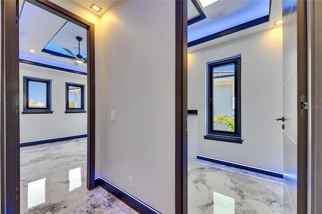 6522 Simone Shores Cir, Apollo Beach, FL 33572 - corridor with marble tiled floors, a raised ceiling, and baseboards