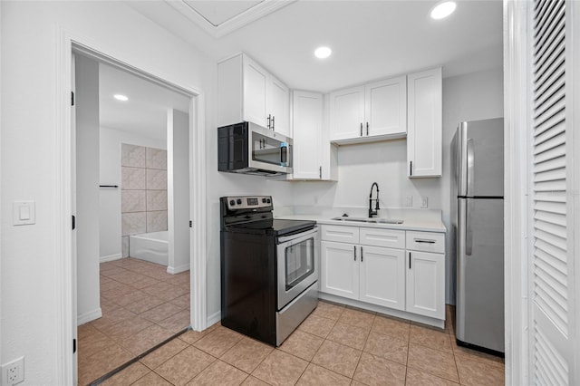 5109 Horton Rd, Plant City, FL 33567 - kitchen with stainless steel appliances, a sink, white cabinetry, light countertops, and light tile patterned flooring