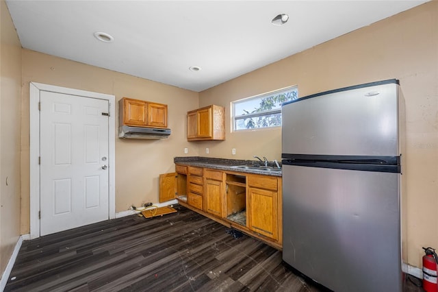 5109 Horton Rd, Plant City, FL 33567 - kitchen featuring freestanding refrigerator, under cabinet range hood, a sink, dark countertops, and dark wood finished floors