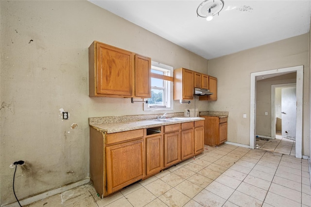 5109 Horton Rd, Plant City, FL 33567 - kitchen with a sink, under cabinet range hood, light countertops, brown cabinets, and light tile patterned floors