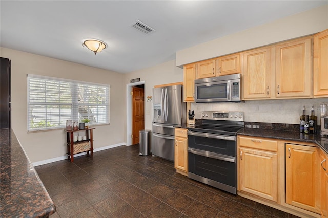 6114 7th Ave S, Gulfport, FL 33707 - kitchen with stainless steel appliances, baseboards, light brown cabinetry, and dark stone counters