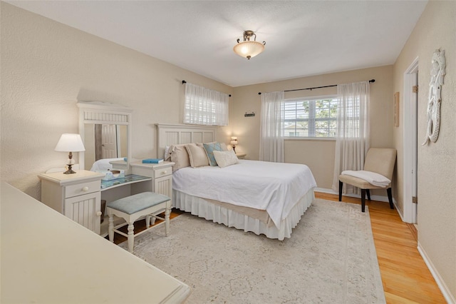 6114 7th Ave S, Gulfport, FL 33707 - bedroom featuring light wood-style flooring, baseboards, and a textured wall