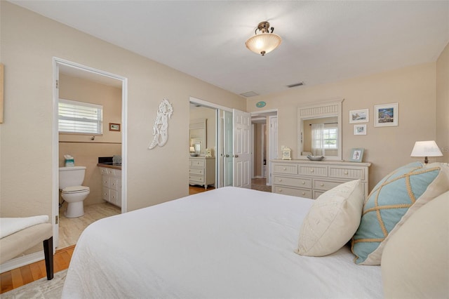 6114 7th Ave S, Gulfport, FL 33707 - bedroom featuring a closet, ensuite bathroom, and light wood-style floors
