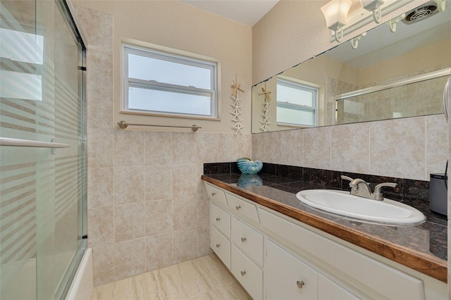 6114 7th Ave S, Gulfport, FL 33707 - full bath featuring vanity, tile walls, and combined bath / shower with glass door