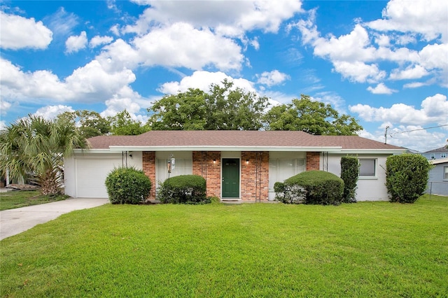 1511 Ave F NE, Winter Haven, FL 33881 - view of front of home with concrete driveway, a front lawn, a garage, brick siding, and roof with shingles