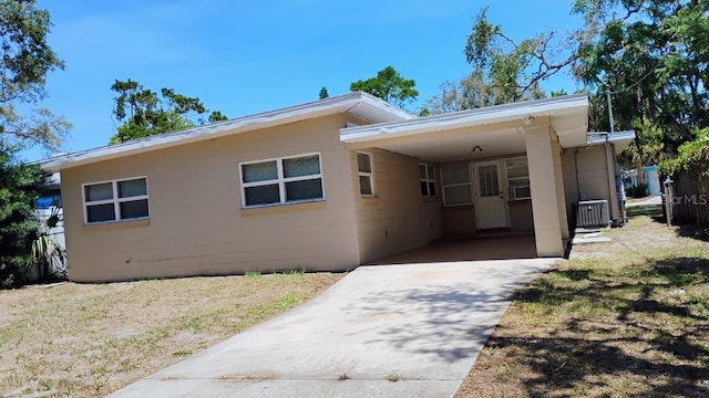 6434 Old Main St, New Port Richey, FL 34653 - view of front of house featuring driveway, an attached carport, central AC unit, and concrete block siding