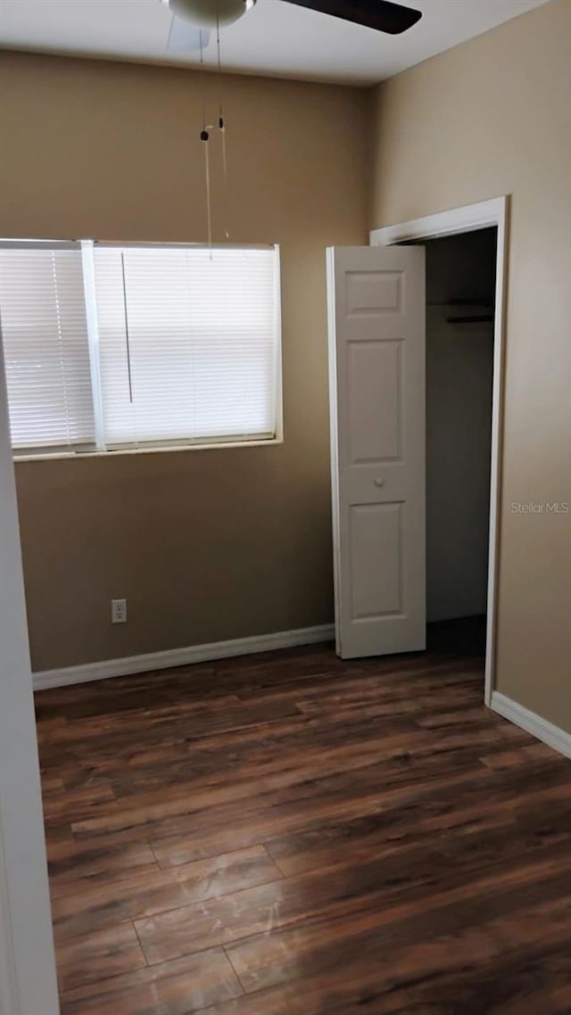 6434 Old Main St, New Port Richey, FL 34653 - unfurnished bedroom with dark wood-style flooring, baseboards, and a closet
