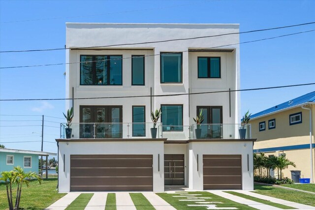 16047 Redington Dr, Redington Beach, FL 33708 - view of front of house featuring stucco siding, a garage, and a balcony