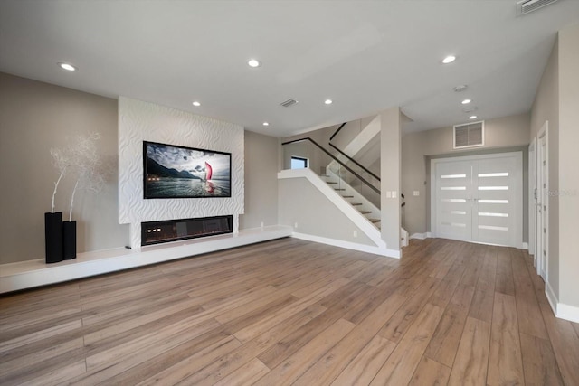 16047 Redington Dr, Redington Beach, FL 33708 - unfurnished living room with wood finished floors, recessed lighting, stairs, a large fireplace, and baseboards