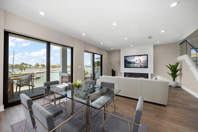 16047 Redington Dr, Redington Beach, FL 33708 - dining space with recessed lighting, wood finished floors, a water view, a fireplace, and baseboards
