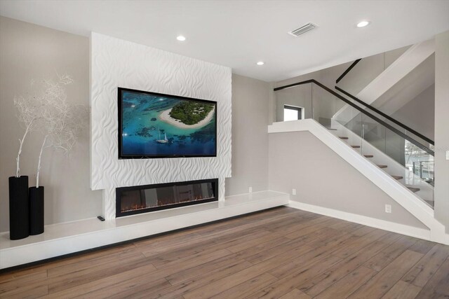 16047 Redington Dr, Redington Beach, FL 33708 - unfurnished living room with wood finished floors, recessed lighting, stairway, a fireplace, and baseboards