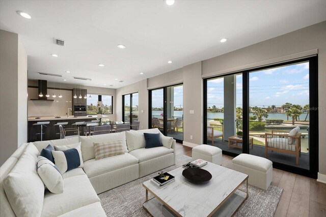 16047 Redington Dr, Redington Beach, FL 33708 - living room featuring light wood-type flooring, recessed lighting, a water view, and baseboards