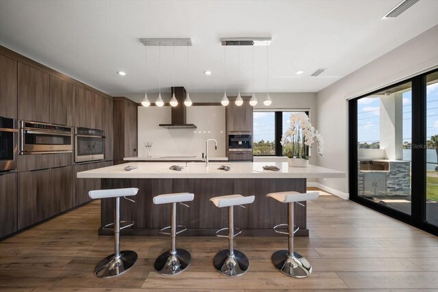 16047 Redington Dr, Redington Beach, FL 33708 - kitchen featuring oven, wall chimney exhaust hood, modern cabinets, light countertops, and recessed lighting
