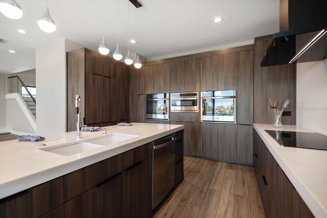 16047 Redington Dr, Redington Beach, FL 33708 - kitchen with appliances with stainless steel finishes, light countertops, a sink, light wood finished floors, and recessed lighting