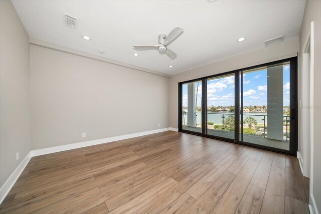 16047 Redington Dr, Redington Beach, FL 33708 - spare room with light wood-style floors, a water view, ceiling fan, baseboards, and recessed lighting