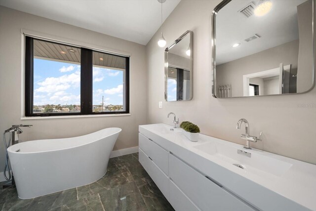 16047 Redington Dr, Redington Beach, FL 33708 - bathroom featuring marble finish floors, a freestanding tub, double vanity, and baseboards
