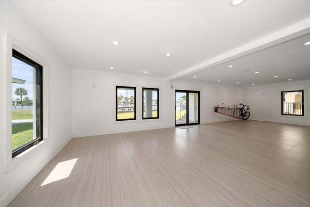 16047 Redington Dr, Redington Beach, FL 33708 - unfurnished living room with plenty of natural light, recessed lighting, beamed ceiling, and light wood-style floors