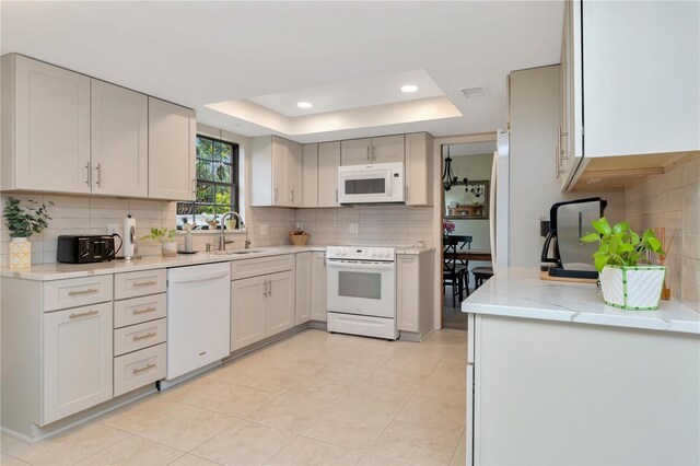 9465 126th Ave, Largo, FL 33773 - kitchen with white appliances, a sink, backsplash, a raised ceiling, and recessed lighting
