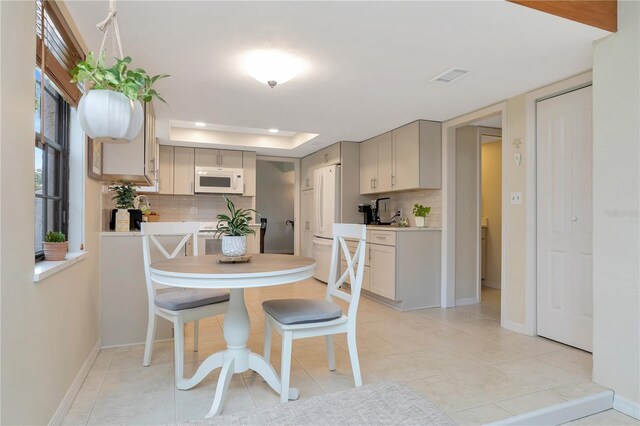 9465 126th Ave, Largo, FL 33773 - dining space with a tray ceiling, baseboards, recessed lighting, and light tile patterned floors