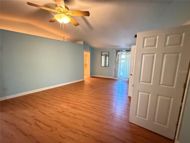 2033 Aaron Pl, Clearwater, FL 33760 - unfurnished room featuring vaulted ceiling, wood finished floors, ceiling fan, and baseboards