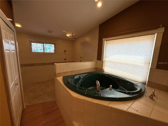 2033 Aaron Pl, Clearwater, FL 33760 - bathroom featuring vaulted ceiling, a tub with jets, a walk in shower, wood finished floors, and recessed lighting