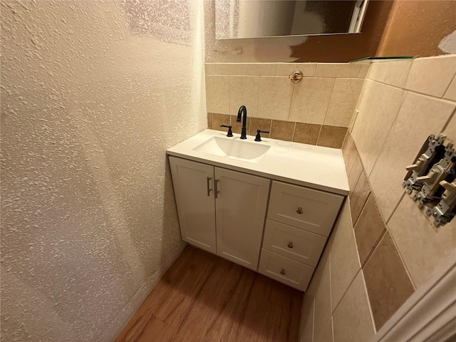 2033 Aaron Pl, Clearwater, FL 33760 - bathroom with decorative backsplash, a textured wall, vanity, and wood finished floors