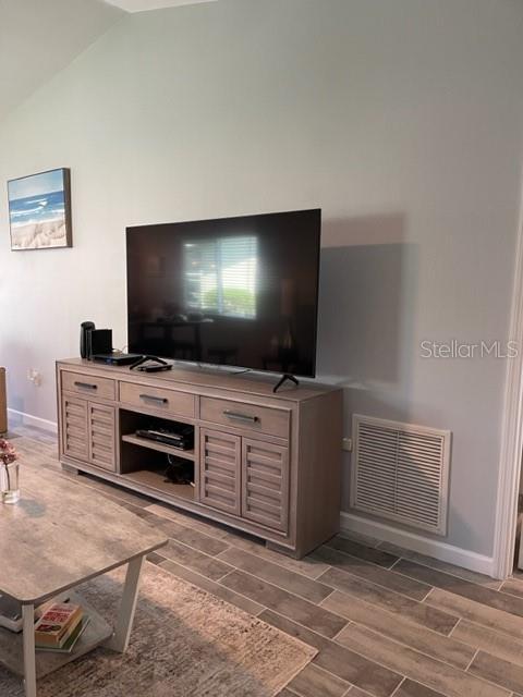2714 60th Avenue Terrace W Unit 12D, Bradenton, FL 34207 - living area featuring lofted ceiling, wood finish floors, and baseboards