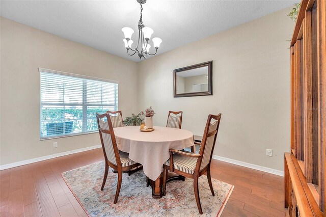 10833 Breaking Rocks Dr, Tampa, FL 33647 - dining space with a chandelier, wood-type flooring, and baseboards