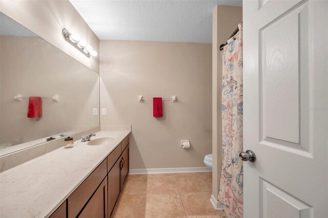 10833 Breaking Rocks Dr, Tampa, FL 33647 - full bath featuring vanity, toilet, tile patterned flooring, baseboards, and a textured ceiling