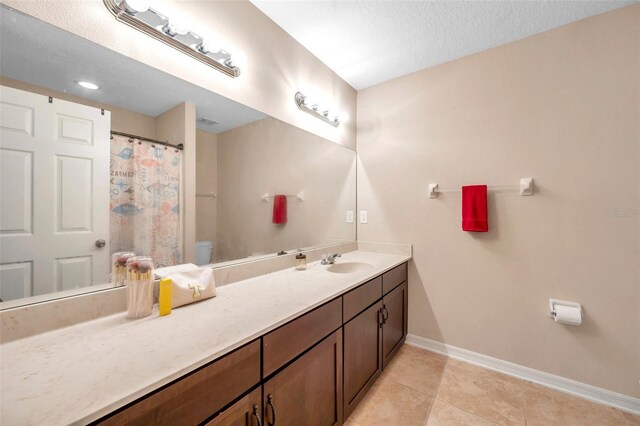 10833 Breaking Rocks Dr, Tampa, FL 33647 - full bath with toilet, vanity, baseboards, tile patterned flooring, and a textured ceiling
