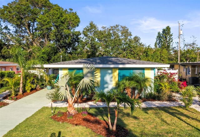 2479 Trade Winds Dr, Dunedin, FL 34698 - view of front of property featuring a front lawn and central AC unit
