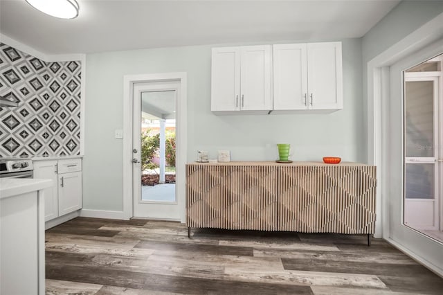 2479 Trade Winds Dr, Dunedin, FL 34698 - kitchen featuring dark wood-type flooring, white cabinets, light countertops, stainless steel electric range, and baseboards