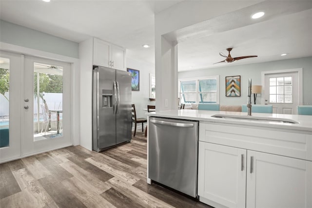 2479 Trade Winds Dr, Dunedin, FL 34698 - kitchen with stainless steel appliances, a ceiling fan, white cabinetry, light wood-style floors, and recessed lighting