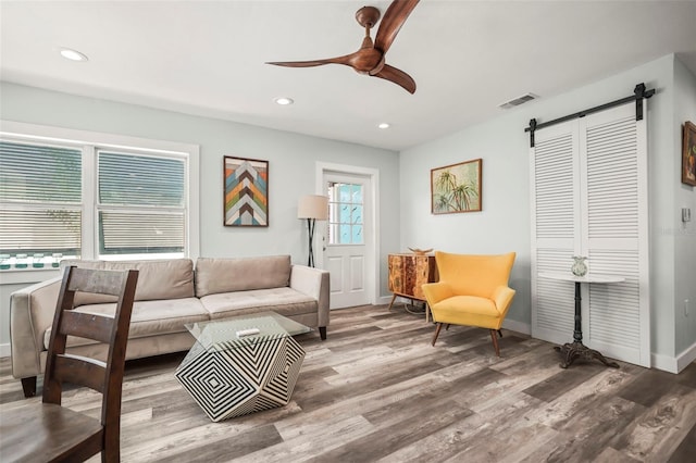 2479 Trade Winds Dr, Dunedin, FL 34698 - living room with a barn door, wood finished floors, ceiling fan, recessed lighting, and baseboards
