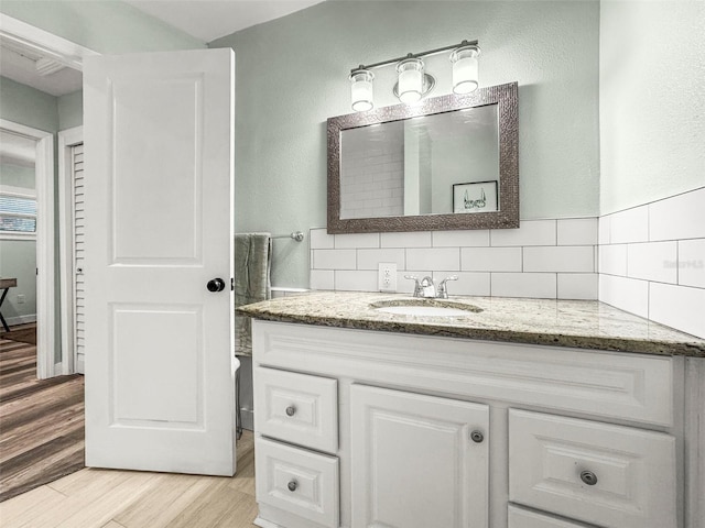 2479 Trade Winds Dr, Dunedin, FL 34698 - bathroom with vanity, wood finished floors, and backsplash