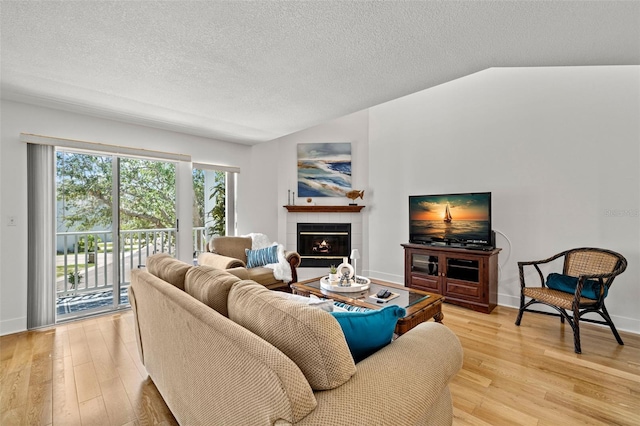 616 Garland Cir, Indian Rocks Beach, FL 33785 - living room with light wood finished floors, a tile fireplace, a textured ceiling, and baseboards