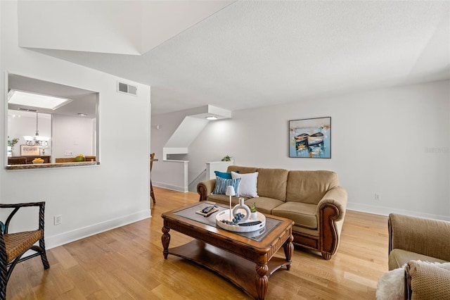 616 Garland Cir, Indian Rocks Beach, FL 33785 - living room featuring light wood-type flooring, baseboards, and a textured ceiling