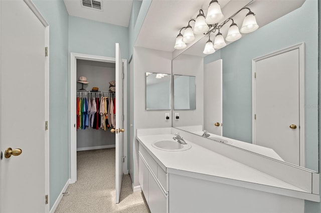 616 Garland Cir, Indian Rocks Beach, FL 33785 - bathroom featuring vanity, a spacious closet, baseboards, and a chandelier