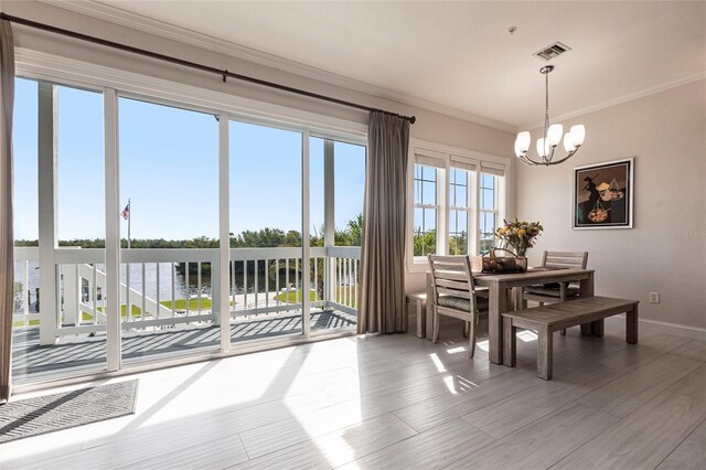 24197 Treasure Island Blvd, Punta Gorda, FL 33955 - dining space featuring a chandelier, ornamental molding, a water view, and wood finished floors
