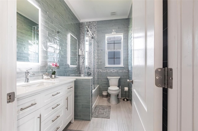 24197 Treasure Island Blvd, Punta Gorda, FL 33955 - bathroom with tile walls, crown molding, vanity, bath / shower combo with glass door, and healthy amount of natural light