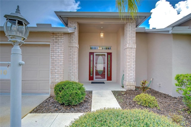 1210 Wolford Dr, Trinity, FL 34655 - property entrance with a garage, stucco siding, and brick siding