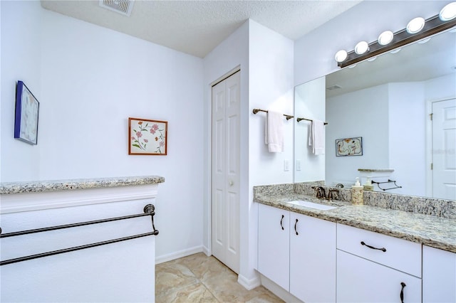 1210 Wolford Dr, Trinity, FL 34655 - bathroom featuring vanity, a closet, baseboards, and a textured ceiling