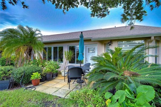 1210 Wolford Dr, Trinity, FL 34655 - back of property with a patio, stucco siding, and roof with shingles