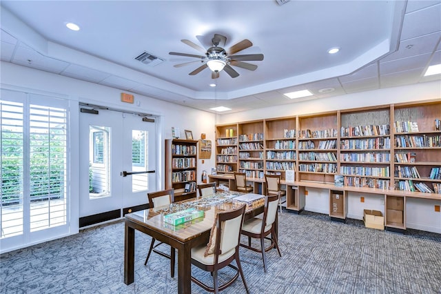 1210 Wolford Dr, Trinity, FL 34655 - office space featuring carpet flooring, a ceiling fan, wall of books, a raised ceiling, and recessed lighting